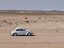 a vw beetle, driving through the desert. 2007-09-02, Sony F828.